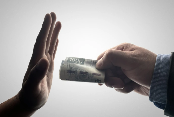 a person holding a stack of cash